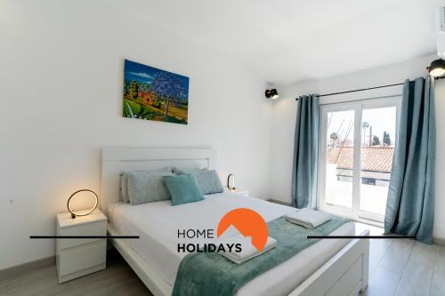 a white bedroom with a bed with a window at #267 Cozy Villa Casablanca in Albufeira