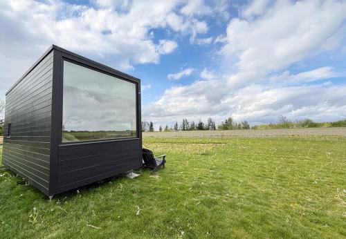 a black tiny house sitting in a field at Camping Hofstede Zonnevliet - Tiny house in Zonnemaire