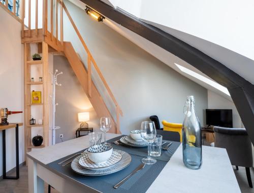 a dining room with a table and a staircase at Le Loft Saint Cyrice in Rodez