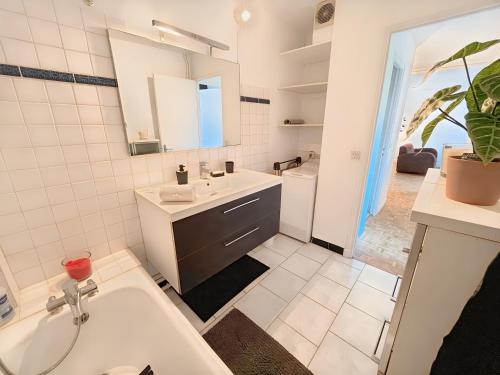 une salle de bain blanche avec un lavabo et un miroir dans l'établissement 10-minute walk to Zenith and Palais des Sports, à Caen