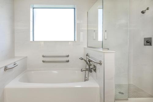 a white bathroom with a tub and a window at The Grove Resort & Water Park Orlando in Orlando