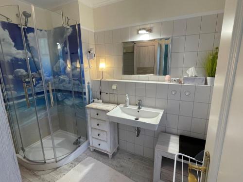 a bathroom with a sink and a shower and a sink at ruhige 3-Raum-Wohnung "BODDENBLICK" mit Balkon und Terrasse in Zingst
