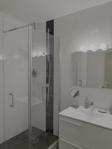 une salle de bain blanche avec une douche et un lavabo dans l'établissement Fairway 4, à Saint-Gély-du-Fesc