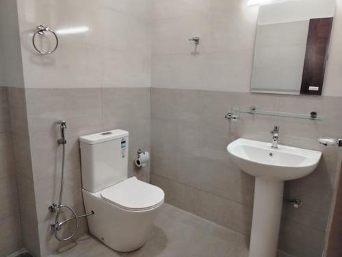 a bathroom with a toilet and a sink at Diora Hotel in Ratnapura