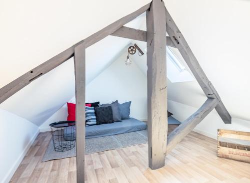 a room with a blue bed in the attic at Le Loft Saint Cyrice in Rodez