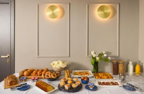 a table filled with different types of bread and pastries at The Oscar Olympic Hotel in Thessaloniki