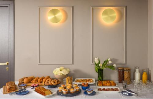 a table topped with different types of pastries and bread at The Oscar Olympic Hotel in Thessaloniki