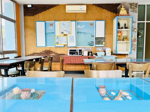 a restaurant with tables and chairs and a kitchen at Sunshine Place Udon in Udon