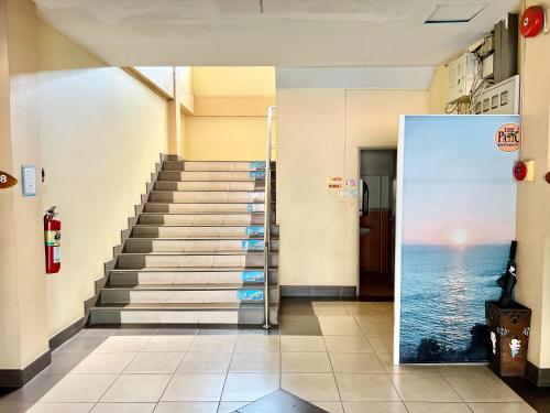 a staircase in a building with a door leading to the ocean at Sunshine Place Udon in Udon