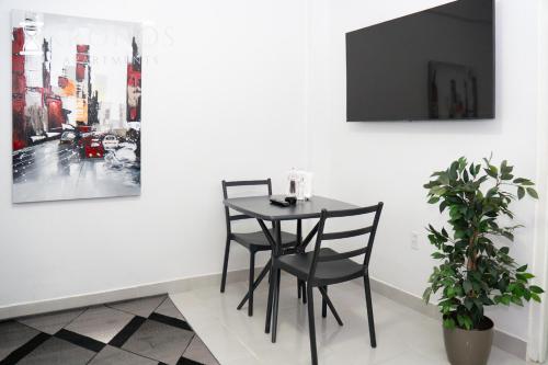 a dining room with a table and two chairs at HHC Apartments Kronos in Paramaribo