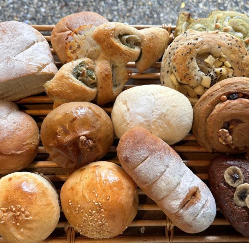 a basket filled with lots of different types of bread at Guest House coco-Rin in Hamamatsu