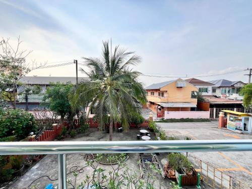 a view of a palm tree from a balcony at Sunshine Place Udon in Udon
