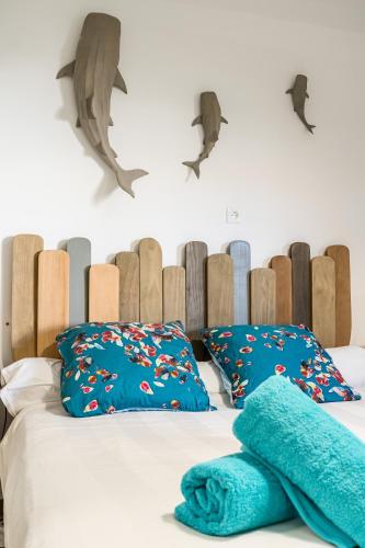 une chambre avec un lit avec des oreillers bleus et une tête de lit en forme de dauphin dans l'établissement Liberté, à La Ciotat