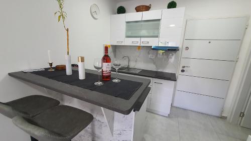 a kitchen with a table with a bottle of wine and a chair at Harmony Srebrno jezero in Veliko Gradište