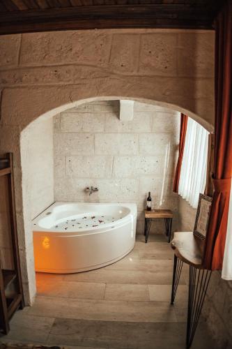 a bath tub in a room with a stone wall at Cappadocia Snora Cave in Nevsehir