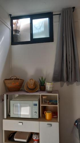 une petite cuisine avec un four micro-ondes et une fenêtre dans l'établissement Studio Robine les halles avec clim, à Narbonne