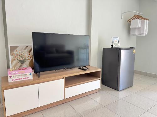 a flat screen tv sitting on top of a wooden entertainment center at Daisy house pattaya in Jomtien Beach