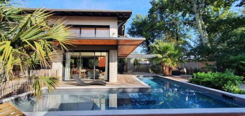 une maison avec une piscine devant une maison dans l'établissement Casa Stella, à Lège-Cap-Ferret