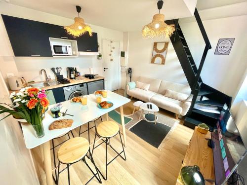 Il comprend une petite cuisine et un salon avec une table et des chaises. dans l'établissement 