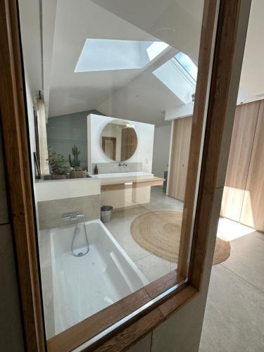 une salle de bain avec une baignoire et un miroir dans l'établissement Casa Stella, à Lège-Cap-Ferret