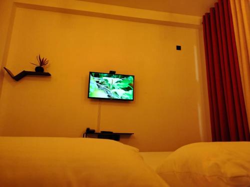 a bedroom with a bed and a tv on the wall at Diora Hotel in Ratnapura