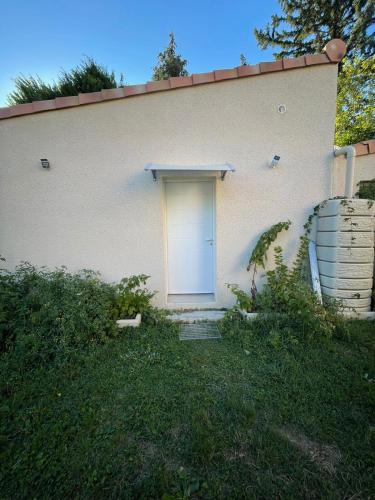 une porte blanche sur une maison blanche avec une cour dans l'établissement L'Hermier à Livron-sur-Drôme, à Livron-sur-Drôme
