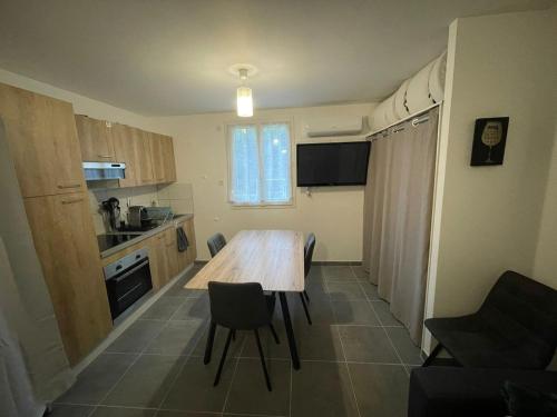 une petite cuisine avec une table et des chaises en bois dans l'établissement L'Hermier à Livron-sur-Drôme, à Livron-sur-Drôme