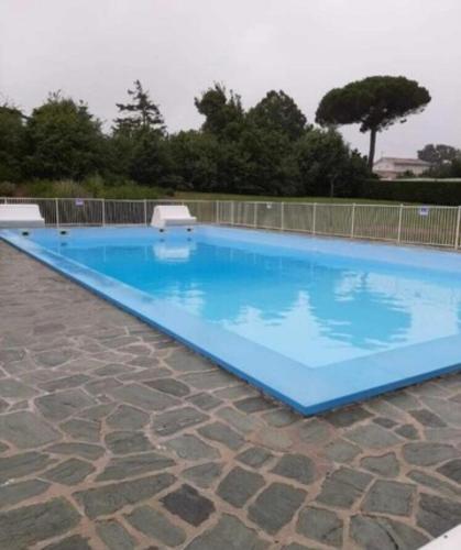 une grande piscine bleue entourée d'une clôture. dans l'établissement Chez Bibi, à Saint-Georges-de-Didonne