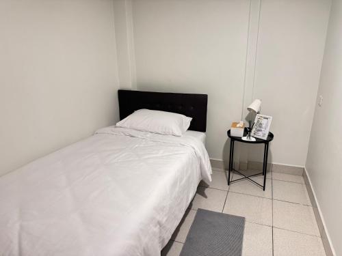 a white bedroom with a bed and a side table at Daisy house pattaya in Jomtien Beach
