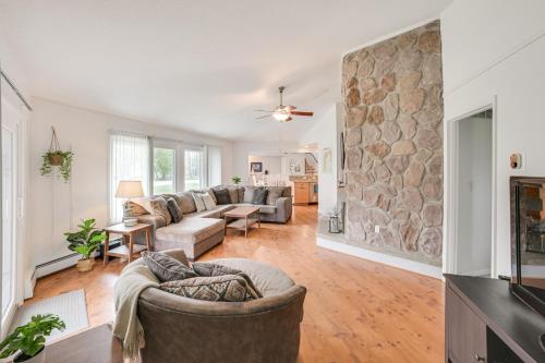an open living room with a stone wall at Close to 3 Ski Areas Michigan Family Retreat! in Charlevoix