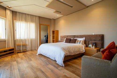 a bedroom with a large bed and a couch at Best 4 Bedroom Luxury Villa In Mediouna in Jbila