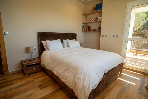 a bedroom with a large bed and a window at Best 4 Bedroom Luxury Villa In Mediouna in Jbila