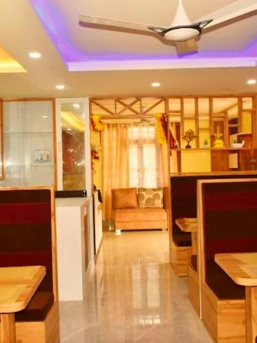 a living room with a ceiling fan and a couch at Hotel khimsika home residency in Pakyong