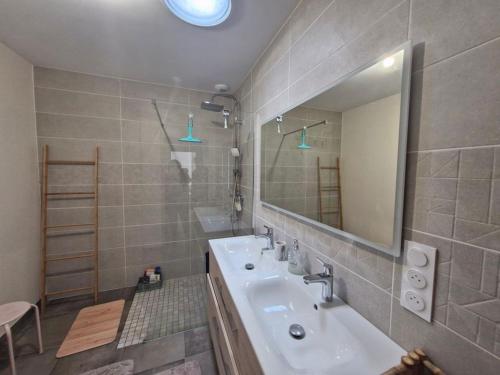 une salle de bain avec un lavabo et un miroir dans l'établissement BELLE MAISON NEUVE FAMILIALE JOLIE VUE DEGAGEE 8 Personnes, à Saint-Jean-de-Monts