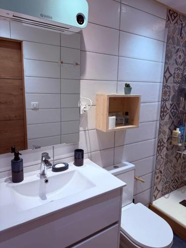 a bathroom with a sink and a toilet and a mirror at Le Micocoulier in Auriol