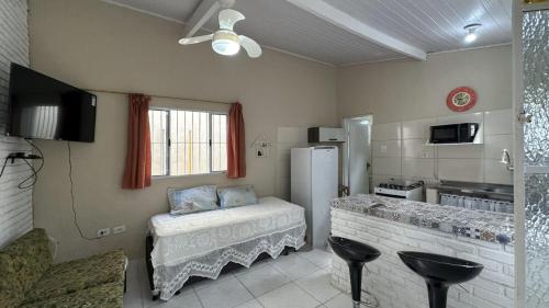 a kitchen with a refrigerator and a counter with stools at Casa confortavel, bem equipada com Wi-Fi e garagem in Massaguassu