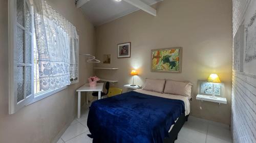 a bedroom with a bed and two windows at Casa confortavel, bem equipada com Wi-Fi e garagem in Massaguassu