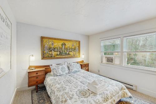 プロビンスタウンにあるBay Colony Retreatのベッドと壁に絵が飾られた寝室