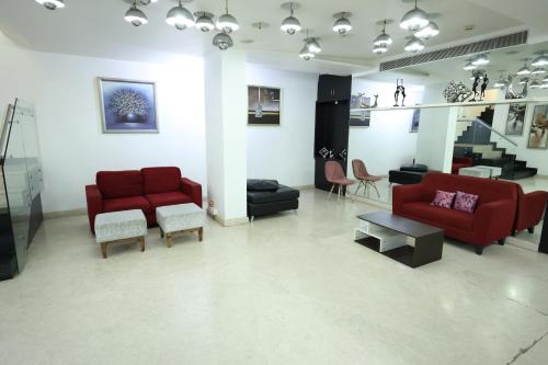 a living room with two red couches and chairs at Purple Brigade, Bangalore in Bengaluru