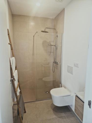 a bathroom with a shower stall and a toilet at Playa Son Moll in Cala Ratjada