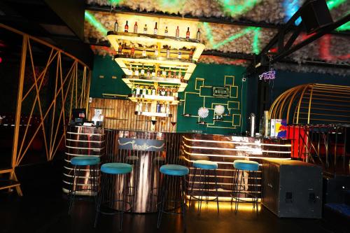 a bar with blue stools and a green wall at Purple Brigade, Bangalore in Bengaluru