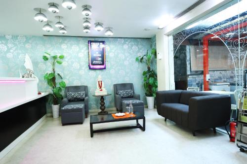 a living room with a couch and chairs and a table at Purple Brigade, Bangalore in Bengaluru