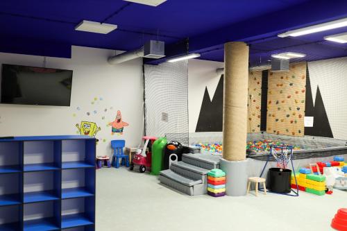 a room with a playroom with toys and a gym at Papaj Resort in Jastrzębia Góra