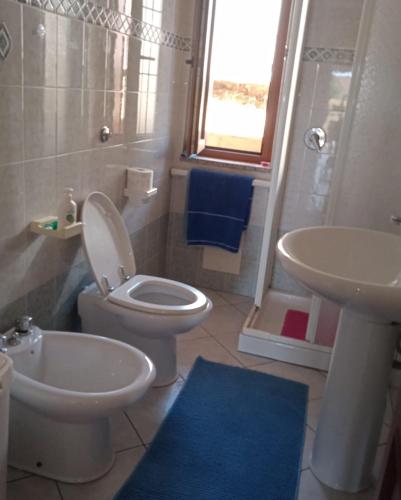 a bathroom with a toilet and a sink at Lungomare 2 in Porto Alabe