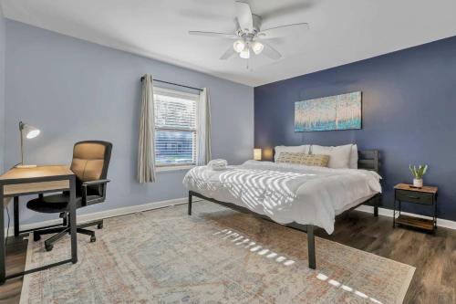 een slaapkamer met een bed, een bureau en een stoel bij Housepitality - The Sunset House in Columbus