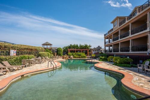 a swimming pool with chairs and a hotel at CSC3E Afternoon Delight in Kill Devil Hills
