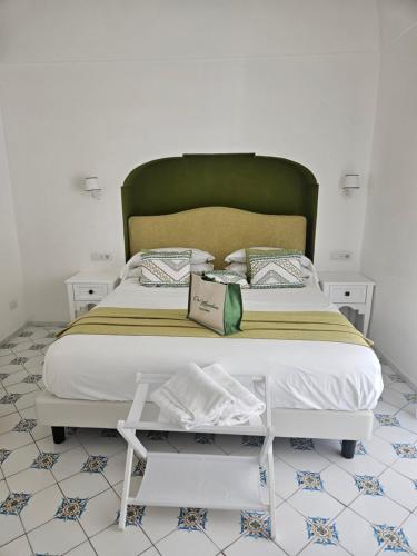 a bed with a green headboard in a room at Casa Mandara B&B in Positano