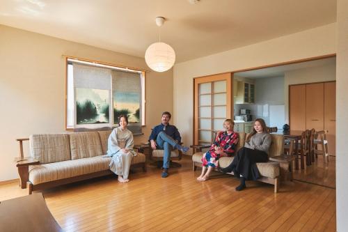 a group of people sitting in a living room at Newly opened special price ,Traditional Japanese house 130 m2 private,3 bedrooms,Fountain,Zen Japanese garden,2 free parking spaces in Beppu