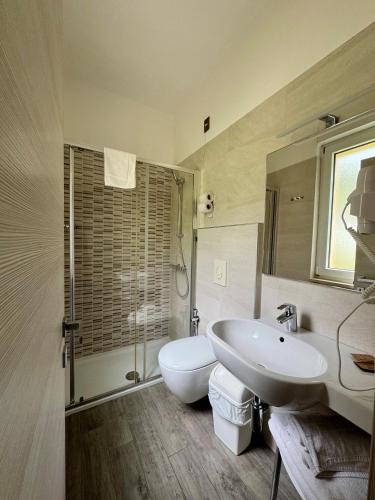 a bathroom with a sink and a toilet and a shower at Hotel Casa Serena in Malcesine