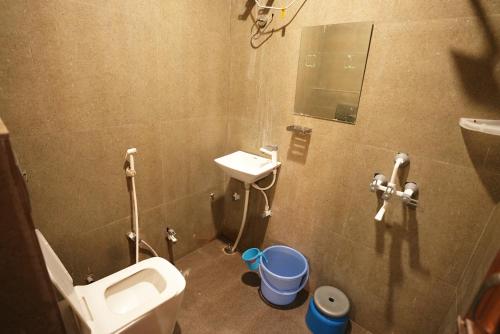 a small bathroom with a toilet and a sink at Shree Krishnam Residency Vrindavan Near ISKCON & Prem Mandir in Vrindāvan